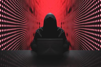 Anonymous hacker with laptop in front of binary code cyber security